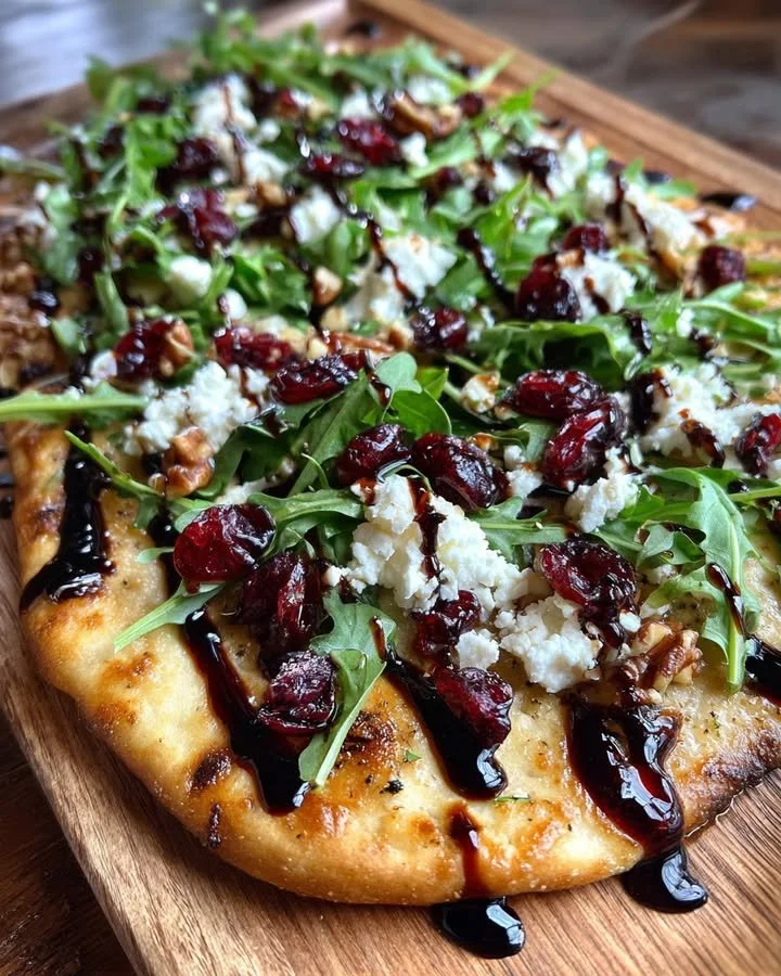Cranberry Balsamic Flatbread with Goat Cheese and Arugula on a wooden platter