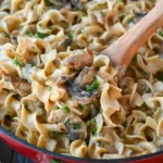 Delicious creamy chicken stroganoff served with noodles and garnished with parsley