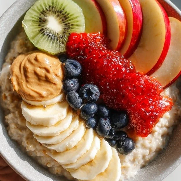 Creamy oatmeal fruit bowl topped with fresh fruits and nuts