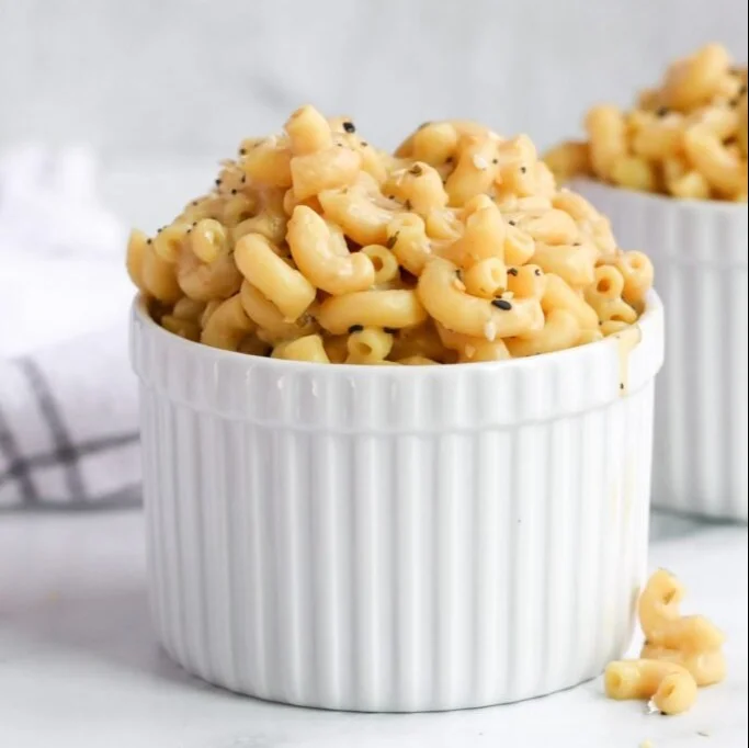 Creamy protein-packed Mac and Cheese in a bowl topped with herbs