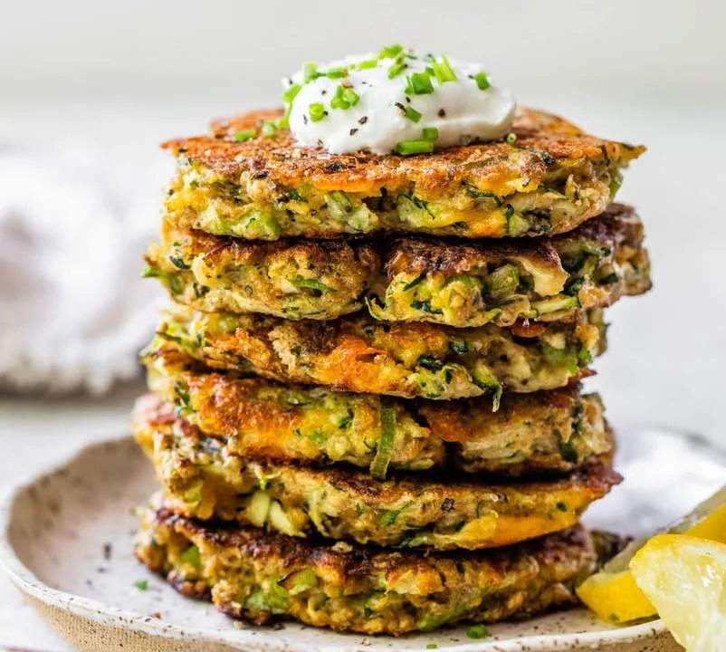 Plate of crispy zucchini fritters garnished with herbs