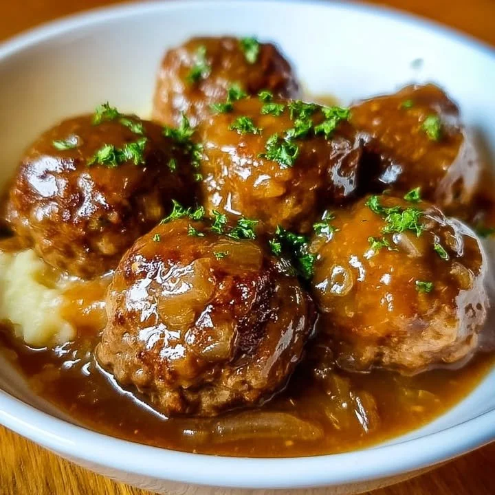 Crock Pot French Onion Meatballs served with melted cheese and fresh herbs