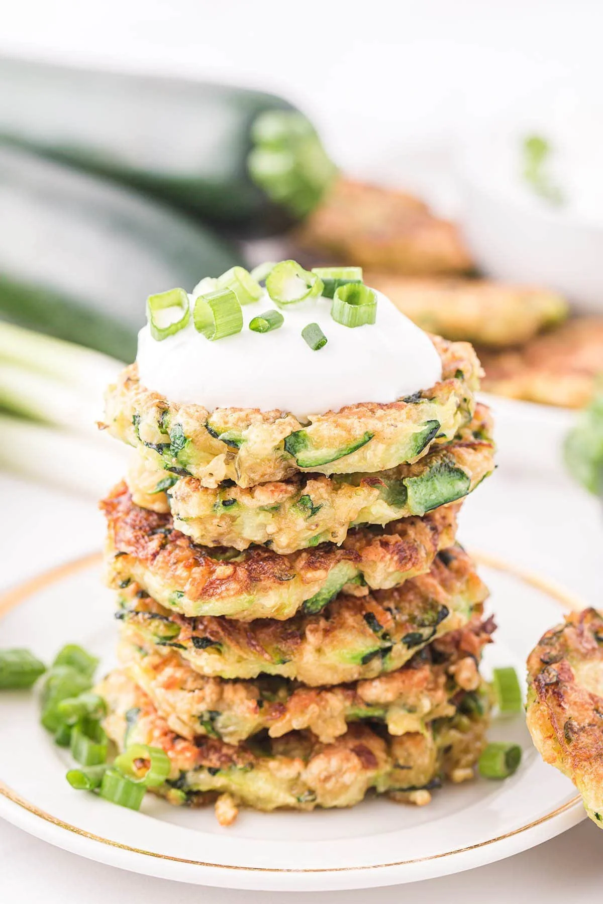 Deliciously crispy zucchini fritters served on a plate with dipping sauce