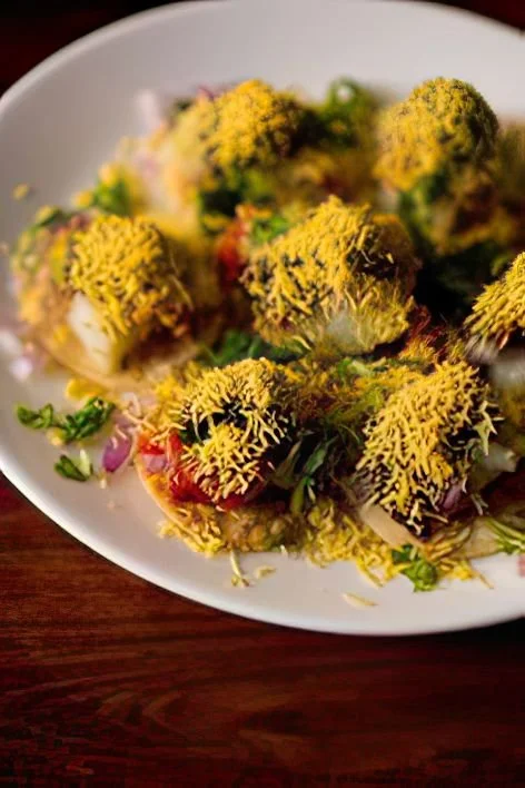 Delicious Sev Puri Chaat topped with fresh herbs, chutneys, and crunchy sev.