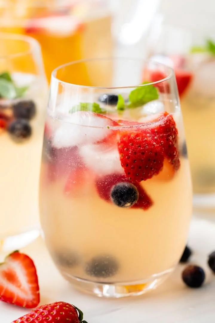 A refreshing glass of easy white sangria with fruits.