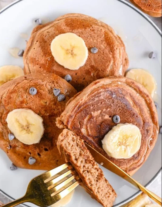 Delicious egg white pancakes stacked on a plate with fresh fruit