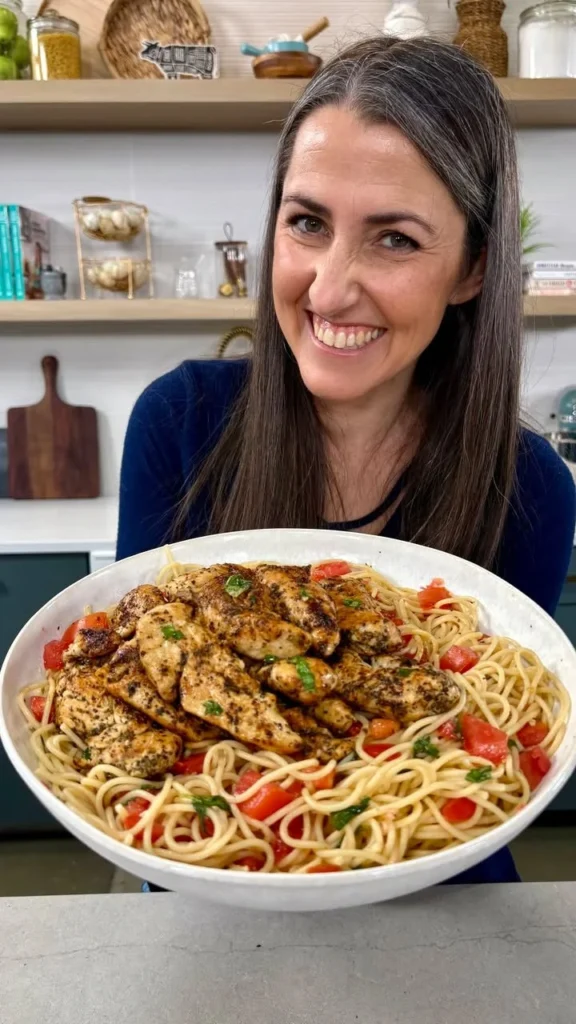 Plato de espagueti de pollo con hierbas frescas y limón