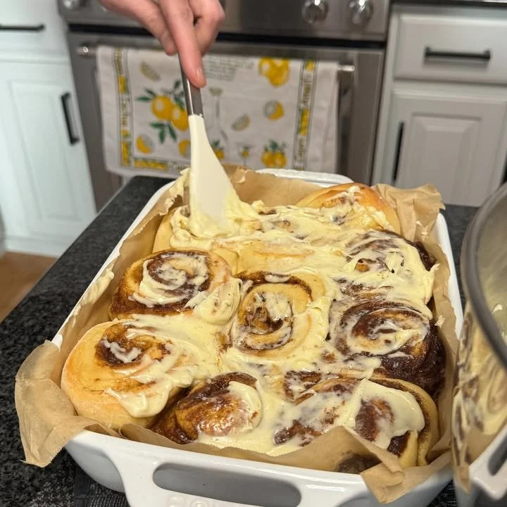 Freshly baked famous cinnamon rolls with icing on a wooden table