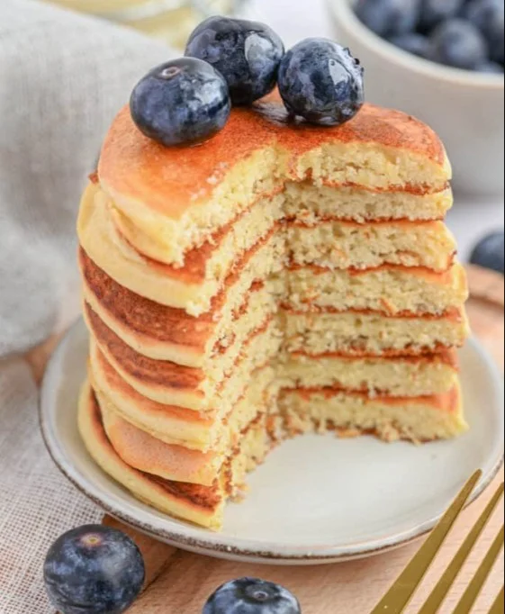 Delicious fluffy protein pancakes stacked with fresh berries