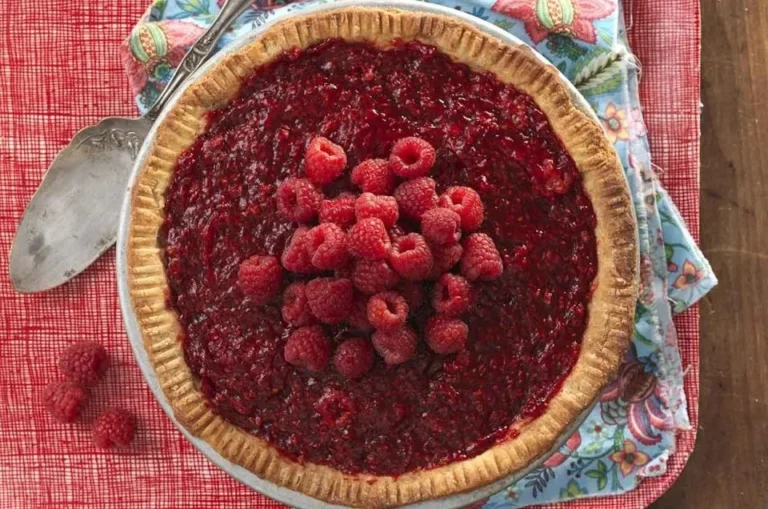 Freshly baked raspberry pie with vibrant red raspberries on top