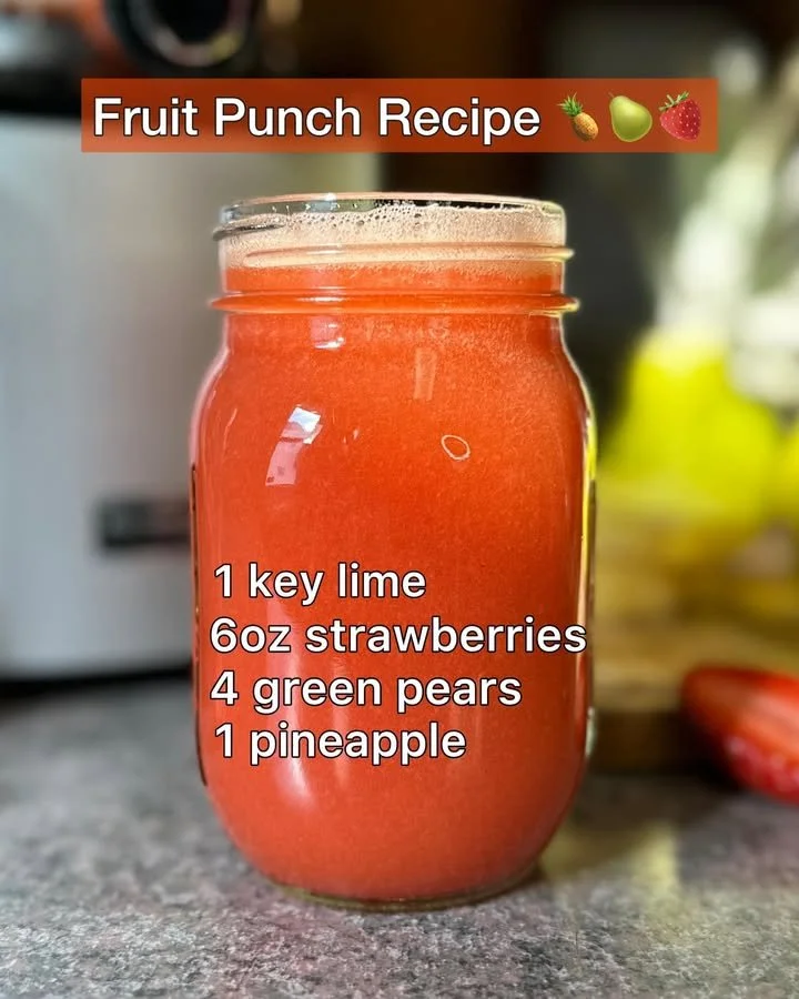 Colorful fruit punch in a glass with fresh fruits and ice cubes.