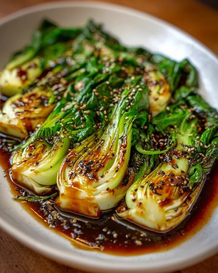 Delicious garlic and soy glazed pan-seared bok choy served on a plate.