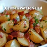 Delicious German Potato Salad served in a bowl with fresh herbs.