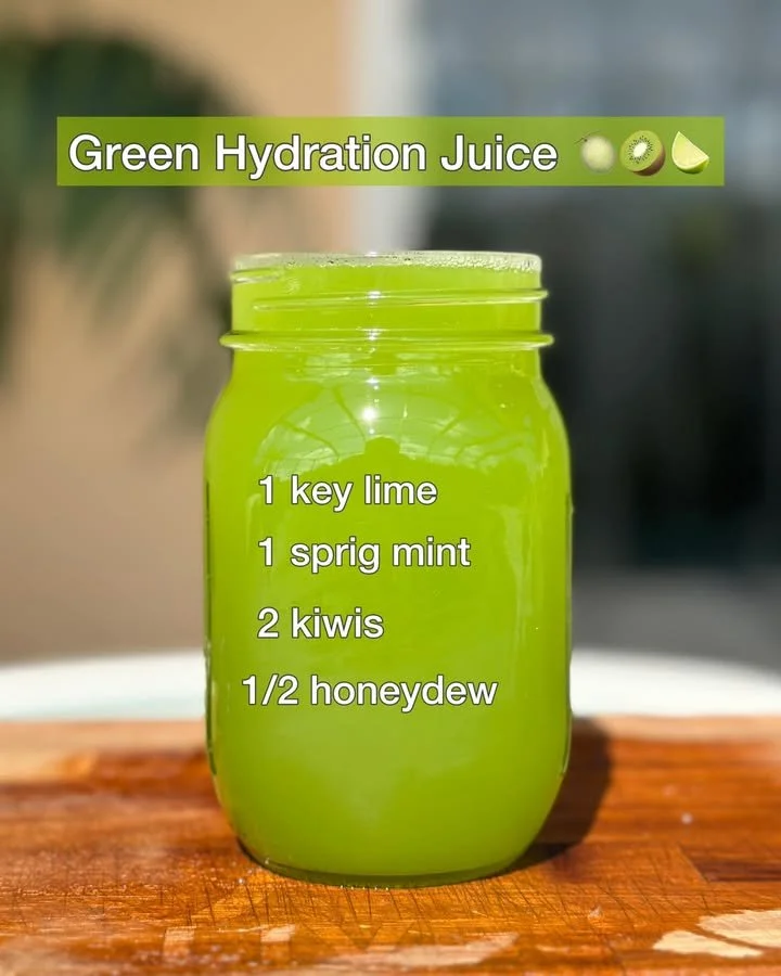 A glass of green hydration juice filled with fresh ingredients like spinach and cucumber.