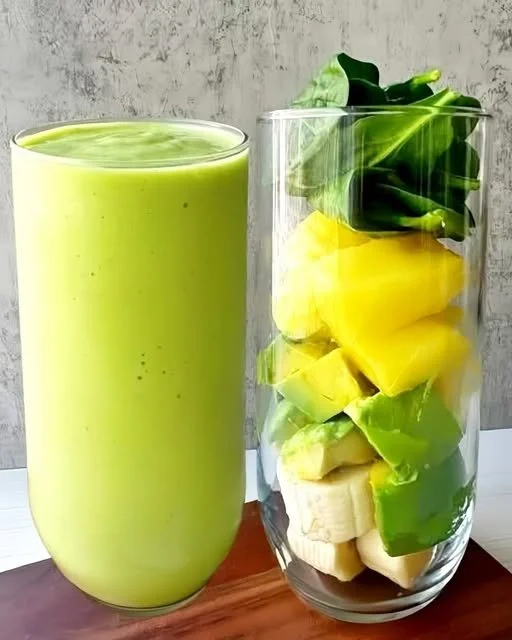 Green mango avocado banana smoothie in a glass with garnishes