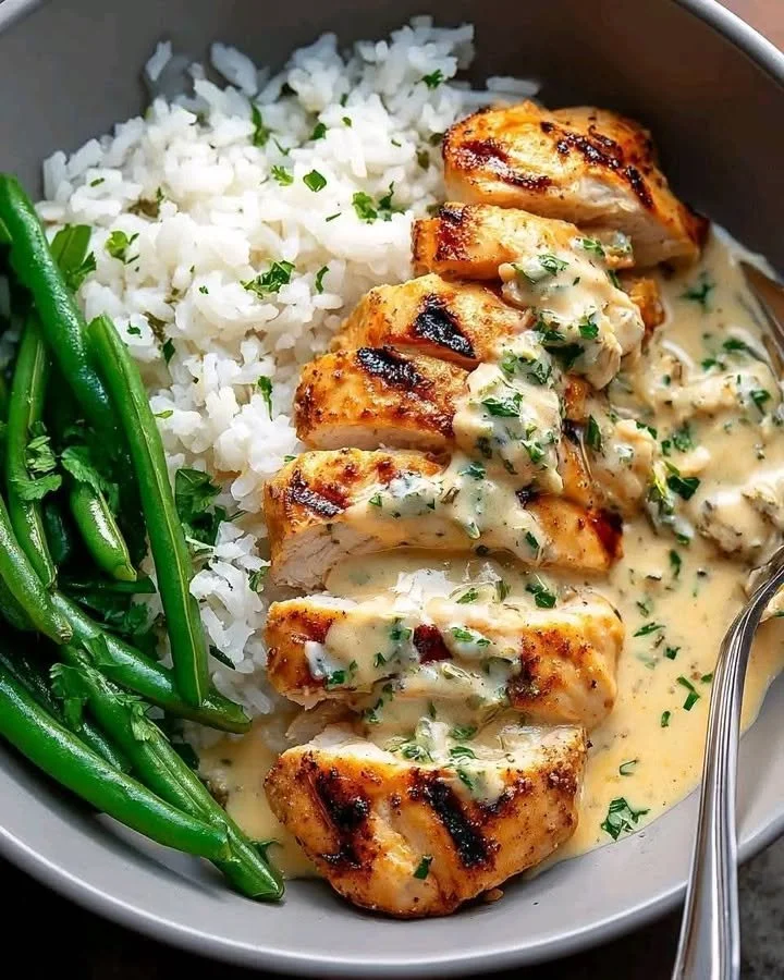 Grilled chicken bowl with creamy garlic herb sauce and fresh vegetables served in a bowl