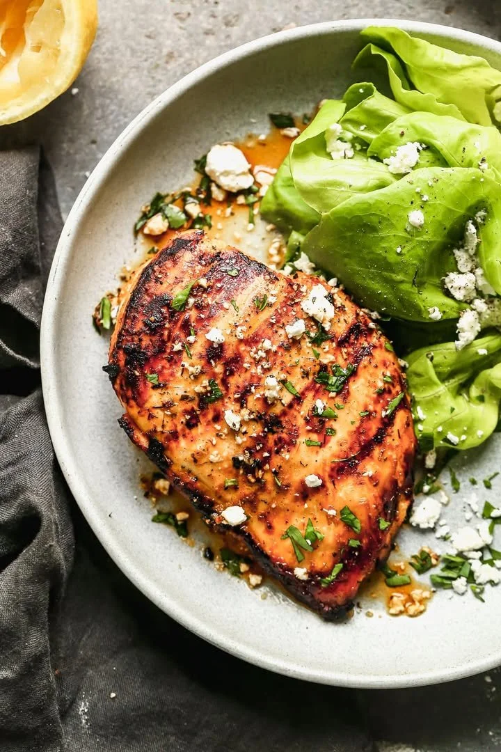 Juicy grilled chicken breast served with fresh herbs and vegetables