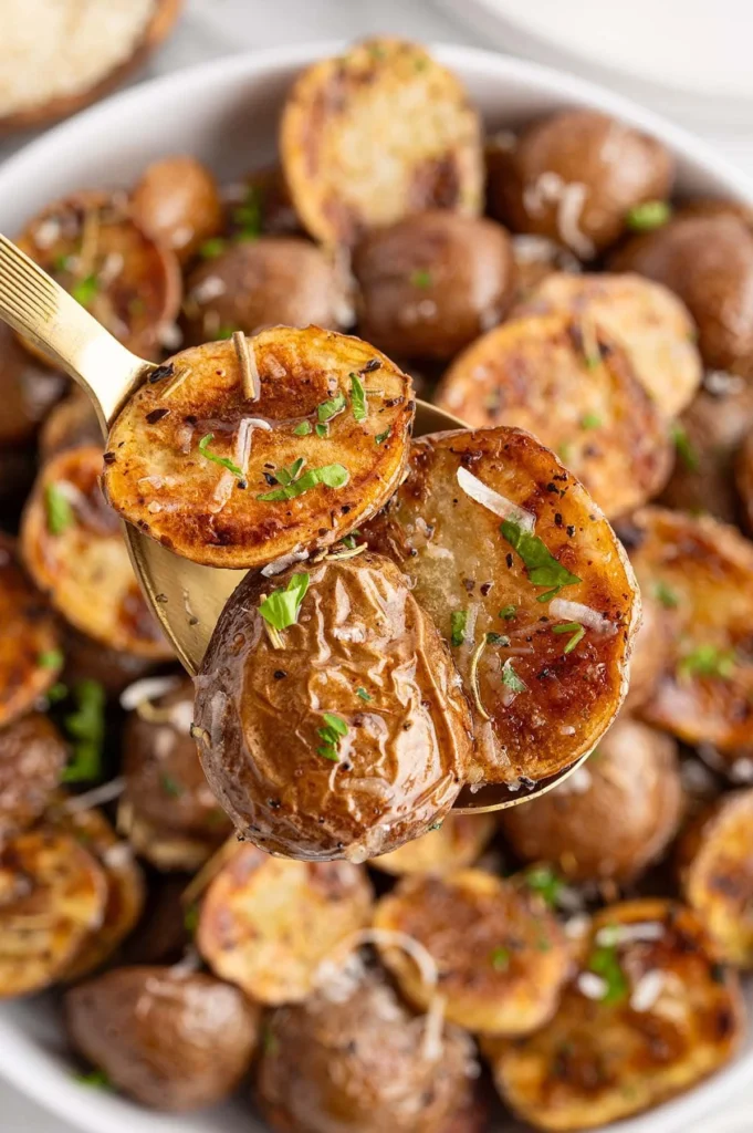 Grilled herb-infused potatoes garnished with fresh herbs on a barbecue grill.