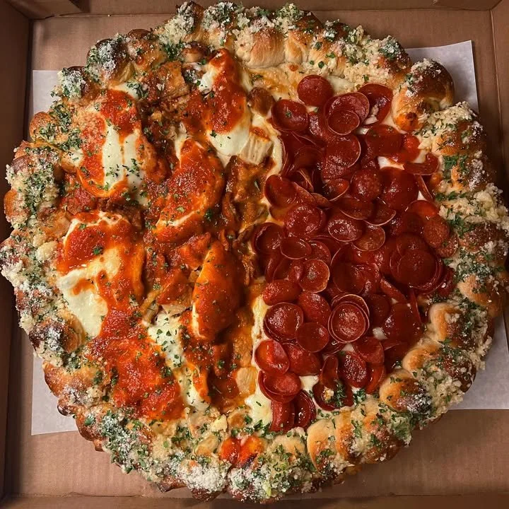 Half Chicken Parm and Hot Honey Pepperoni Cups Pizza on a wooden table