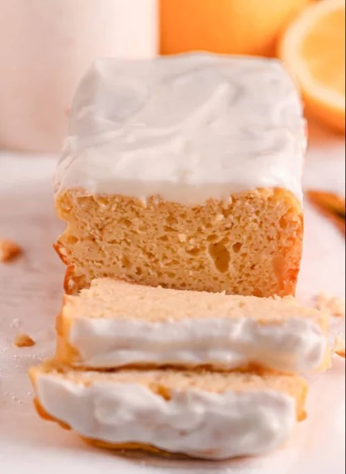 Healthy lemon cake on a plate with fresh lemons and whipped cream