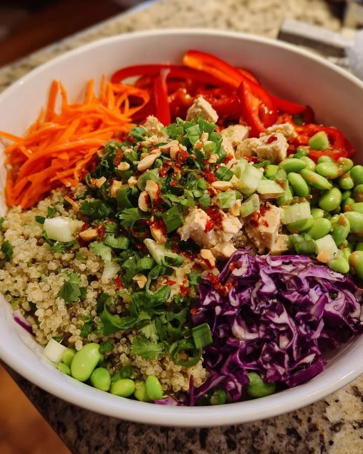 High Protein Thai Quinoa Salad topped with fresh vegetables and dressing