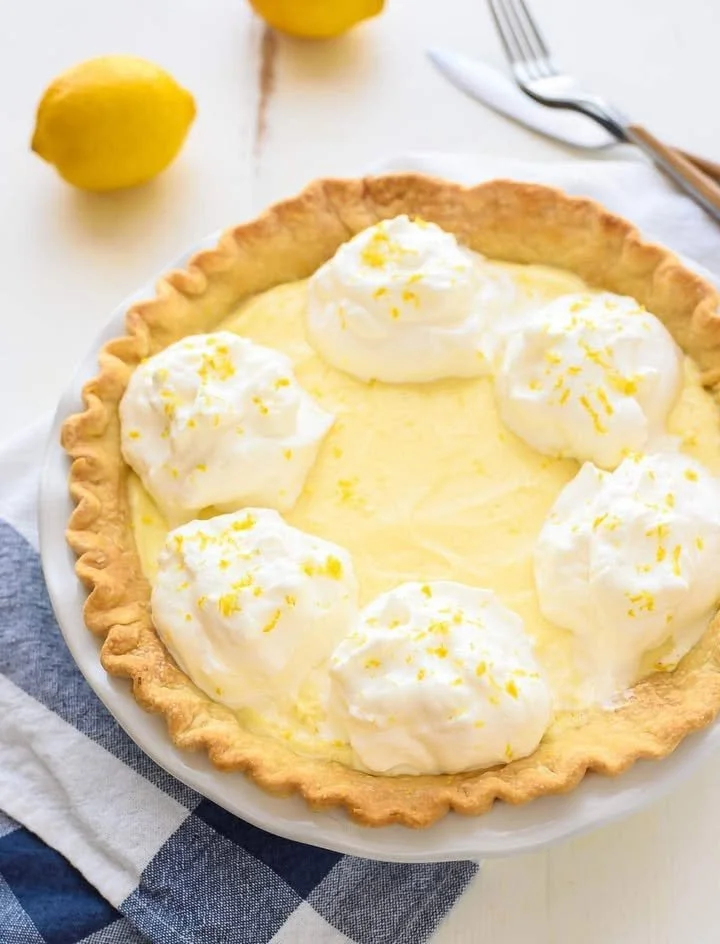 Delicious homemade Lemon Cream Pie topped with whipped cream and lemon zest.