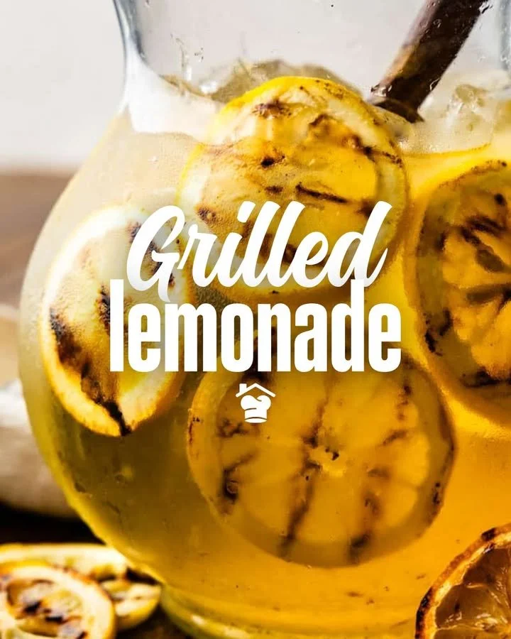 Limonada a la parrilla en un vaso con rodajas de limón y hierbas frescas.