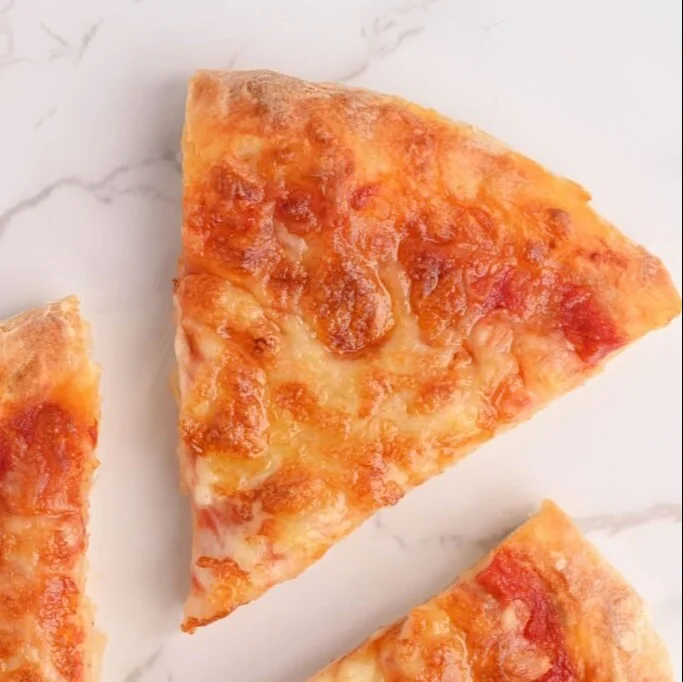 A slice of low calorie pizza topped with fresh vegetables and lean protein.