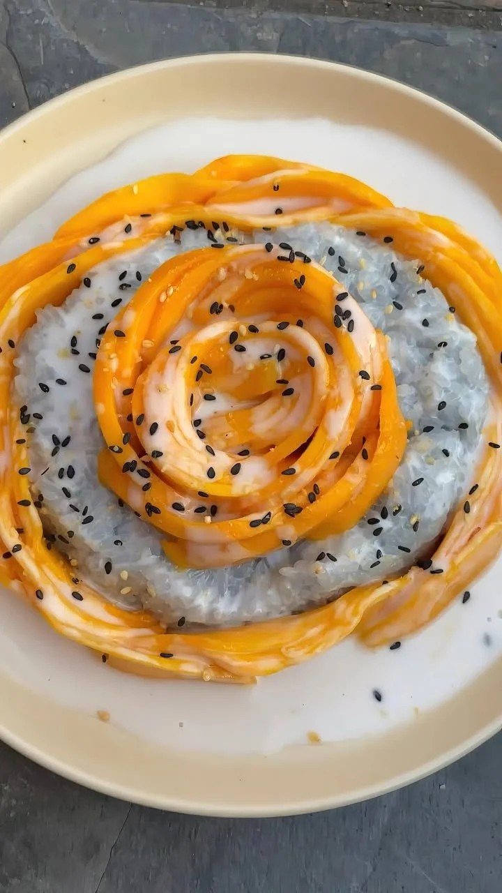 Delicious bowl of Mango Sticky Rice with fresh mango and coconut sauce on top