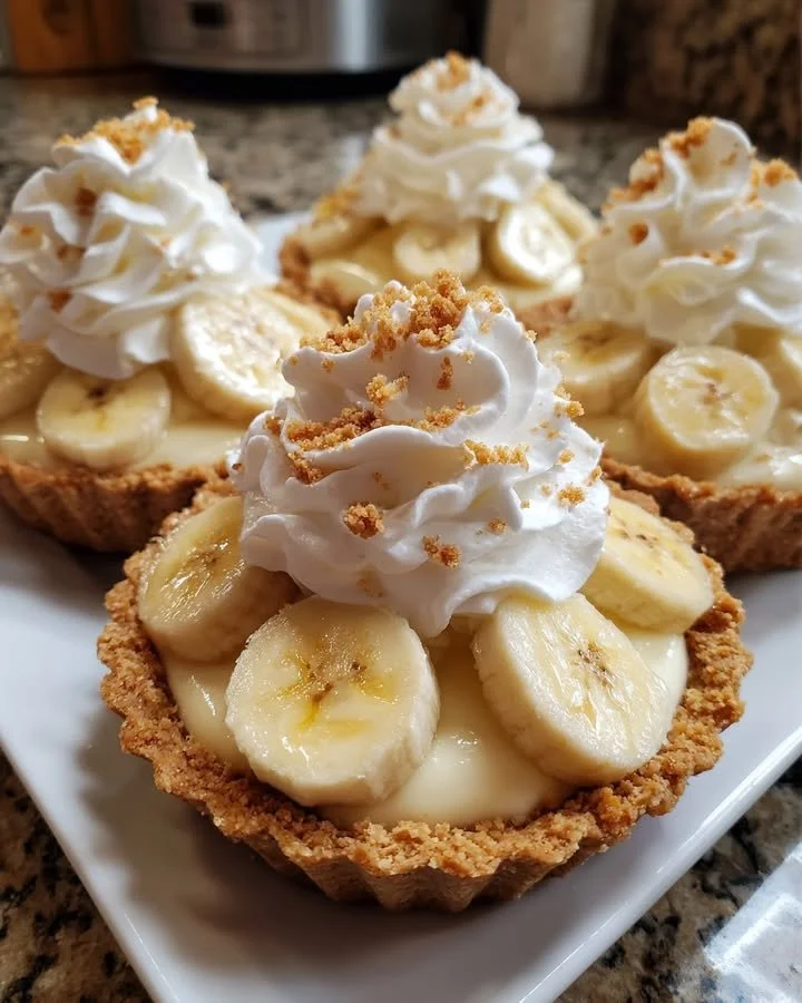 No-bake mini banana cream pies topped with whipped cream and banana slices