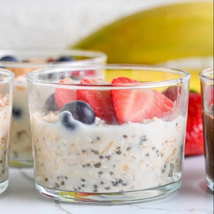 Bowl of colorful overnight oats topped with fresh fruits and nuts