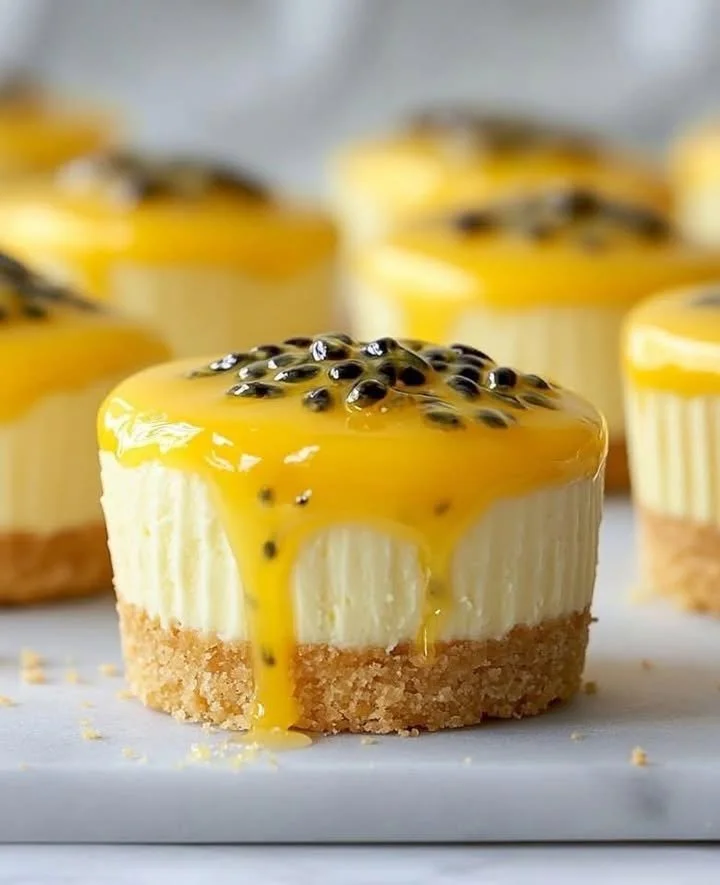 Passionfruit Drip Mini Cheesecakes topped with vibrant fruit sauce
