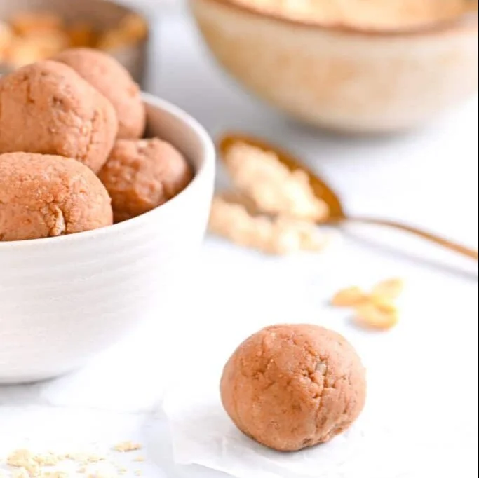 Homemade PB2 Protein Balls stacked on a wooden table