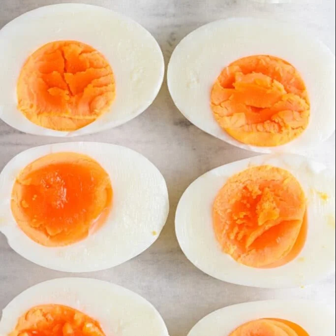 Perfectly cooked hard-boiled eggs on a plate with garnish