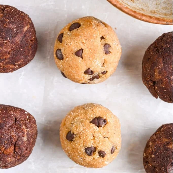 A variety of homemade protein balls displayed on a wooden surface.
