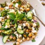 A vibrant Quinoa Chickpea Salad with fresh vegetables and herbs.