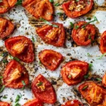 Plate of roasted tomatoes drizzled with olive oil and herbs