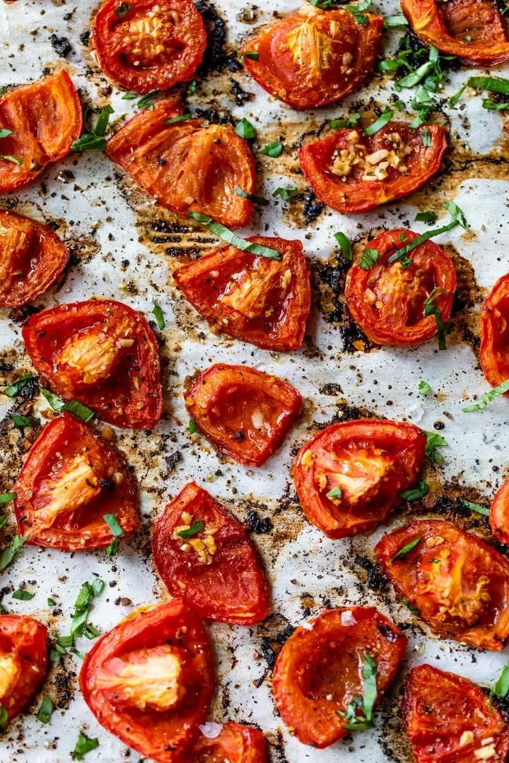 Plate of roasted tomatoes drizzled with olive oil and herbs