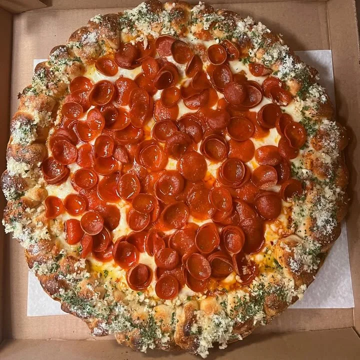 Roni Cups Round Sicilian Pizza with Garlic Knot Crust, featuring crispy edges and flavorful toppings