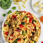 A vibrant bowl of Salad Supreme Pasta Salad with fresh vegetables and dressing.