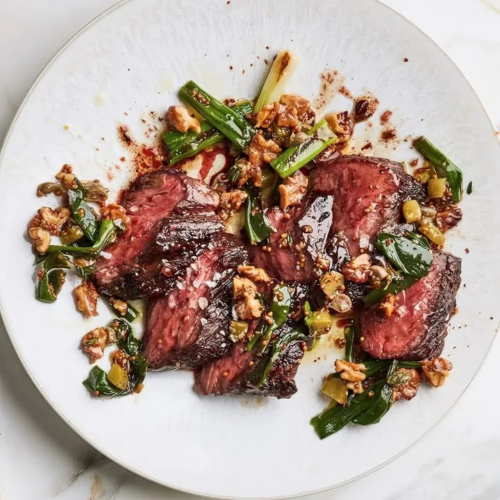 Seared beef with scallions and walnuts drizzled with balsamic glaze