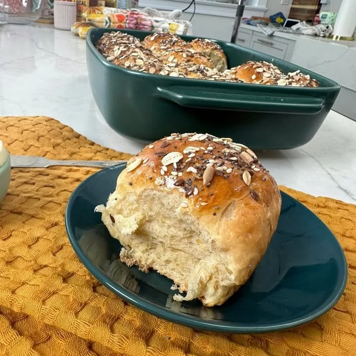 Soft and fluffy milk and honey oatmeal dinner rolls on a wooden table