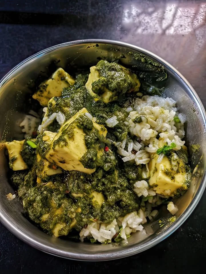Bowl of Spinach Paneer served with a side of steaming rice