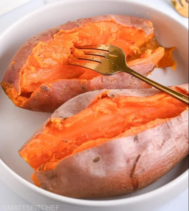 Steamed sweet potatoes served on a plate with herbs