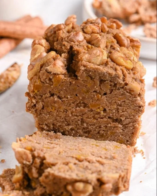 Slice of sugar-free banana bread with ripe bananas on a wooden table