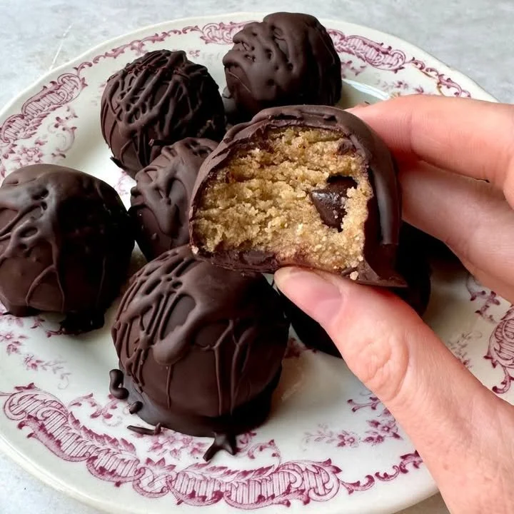Tahini chocolate chip cookie dough bites on a plate, a tasty vegan treat.