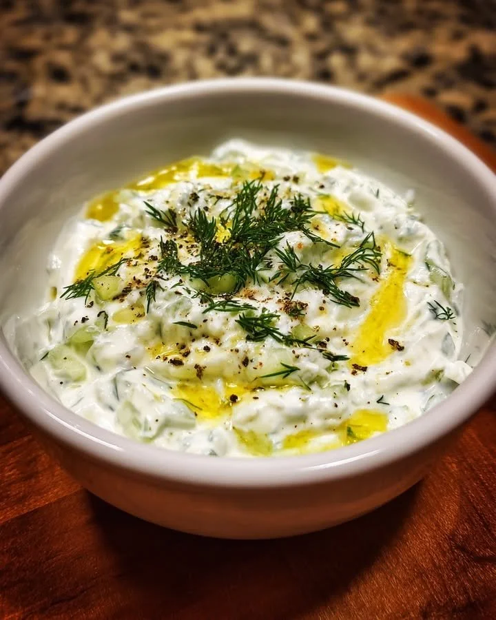 Delicious Tzatziki Sauce in a bowl, garnished with herbs and served with pita bread
