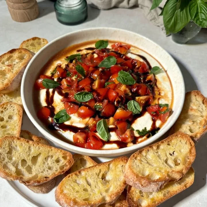 Whipped feta bruschetta dip served with crusty bread and fresh herbs.
