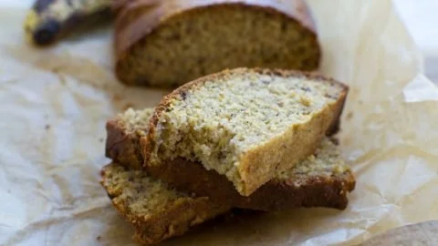 A delicious slice of air fryer banana bread on a wooden table.