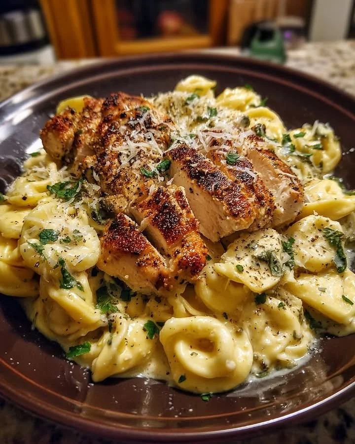 Creamy Asiago Tortellini Alfredo with grilled chicken on a plate